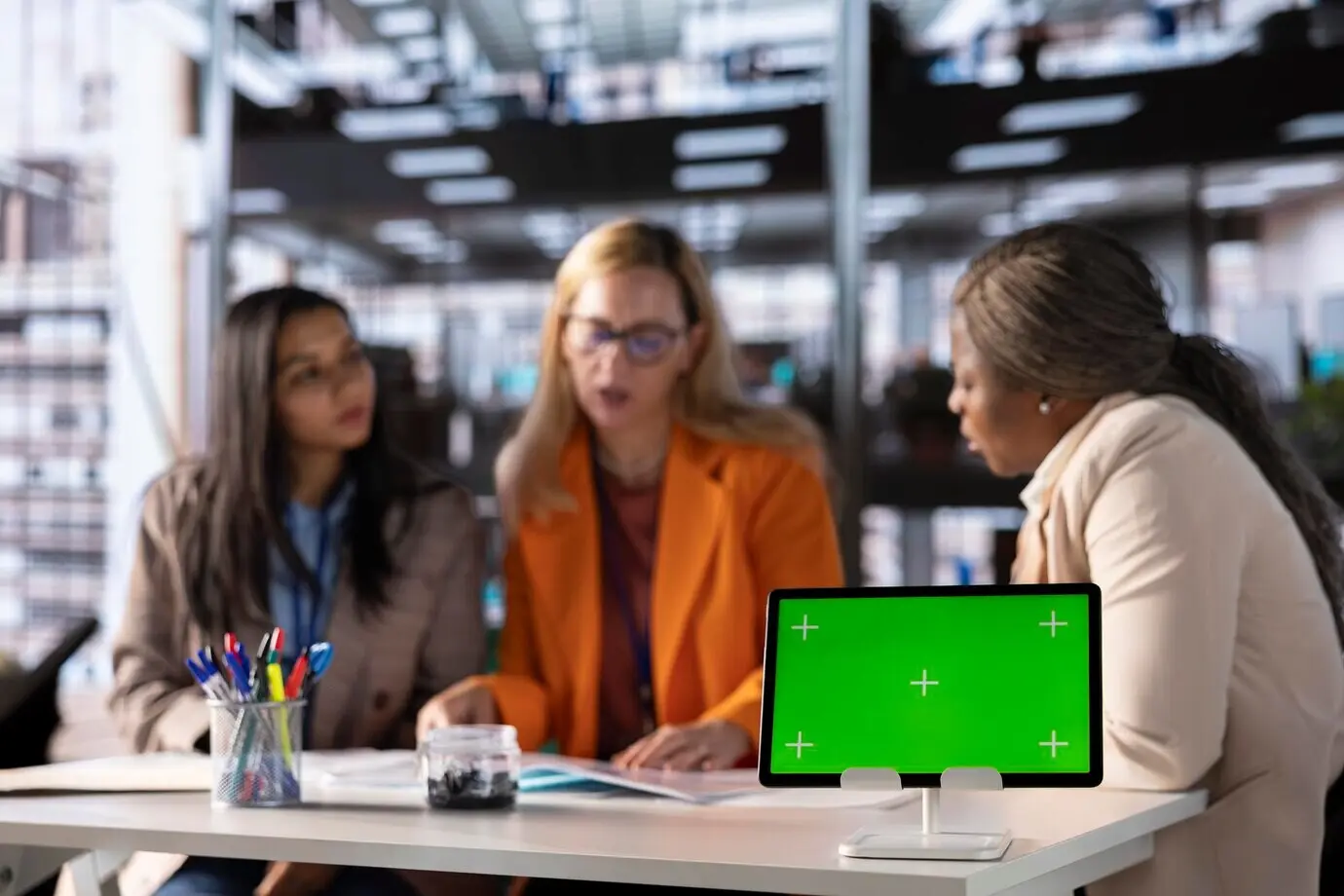 Grupo de emprendedoras del sector empresarial utilizando un mockup con espacio para texto.